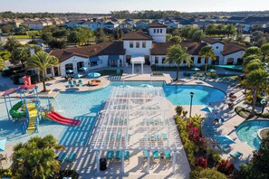 Un resort con una amplia piscina central, varias piscinas más pequeñas y un tobogán de agua.
