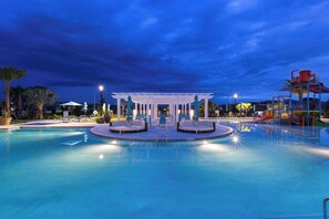 Piscina con zona salotto centrale e area giochi per bambini.