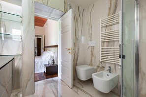 A modern bathroom with a marble floor, a bidet, a glass shower enclosure, and a glass shower door. - 3111 Villa Carra by Perle di Puglia (Parabita)