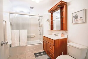 Bathtub, hair dryer, towels, shampoo