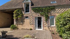 A traditional brick house with a tiled roof, a wooden deck, and a small garden area. - Cozy Countryside Cottage with Spacious Garden – Sleeps 4-5 (Douchy-Montcorbon-Douchy)
