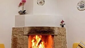 Una habitación acogedora con chimenea de piedra, muebles de madera y techo con vigas a la vista.