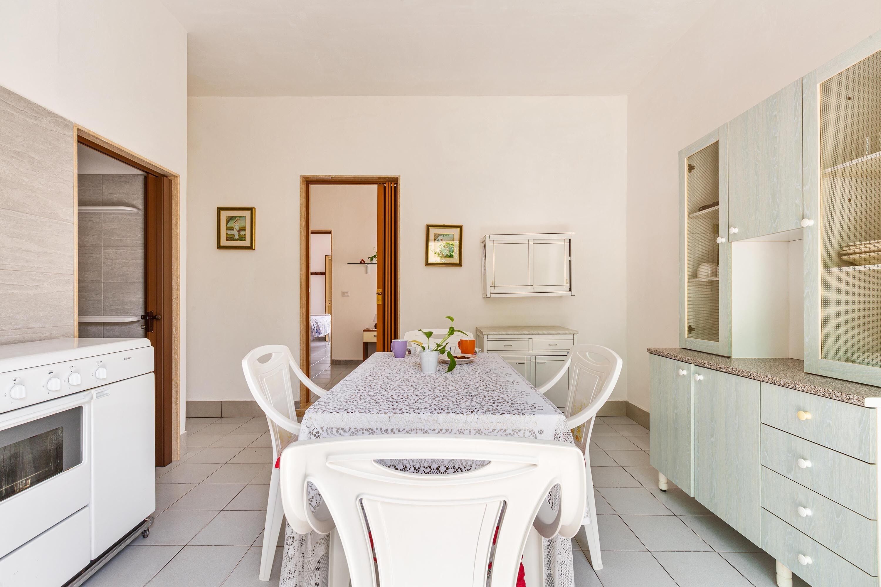 Uma cozinha moderna com uma mesa de jantar, cadeiras e forno embutido.