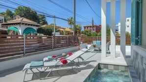 Un espace aménagé au bord de la piscine, avec des chaises longues et une petite piscine.