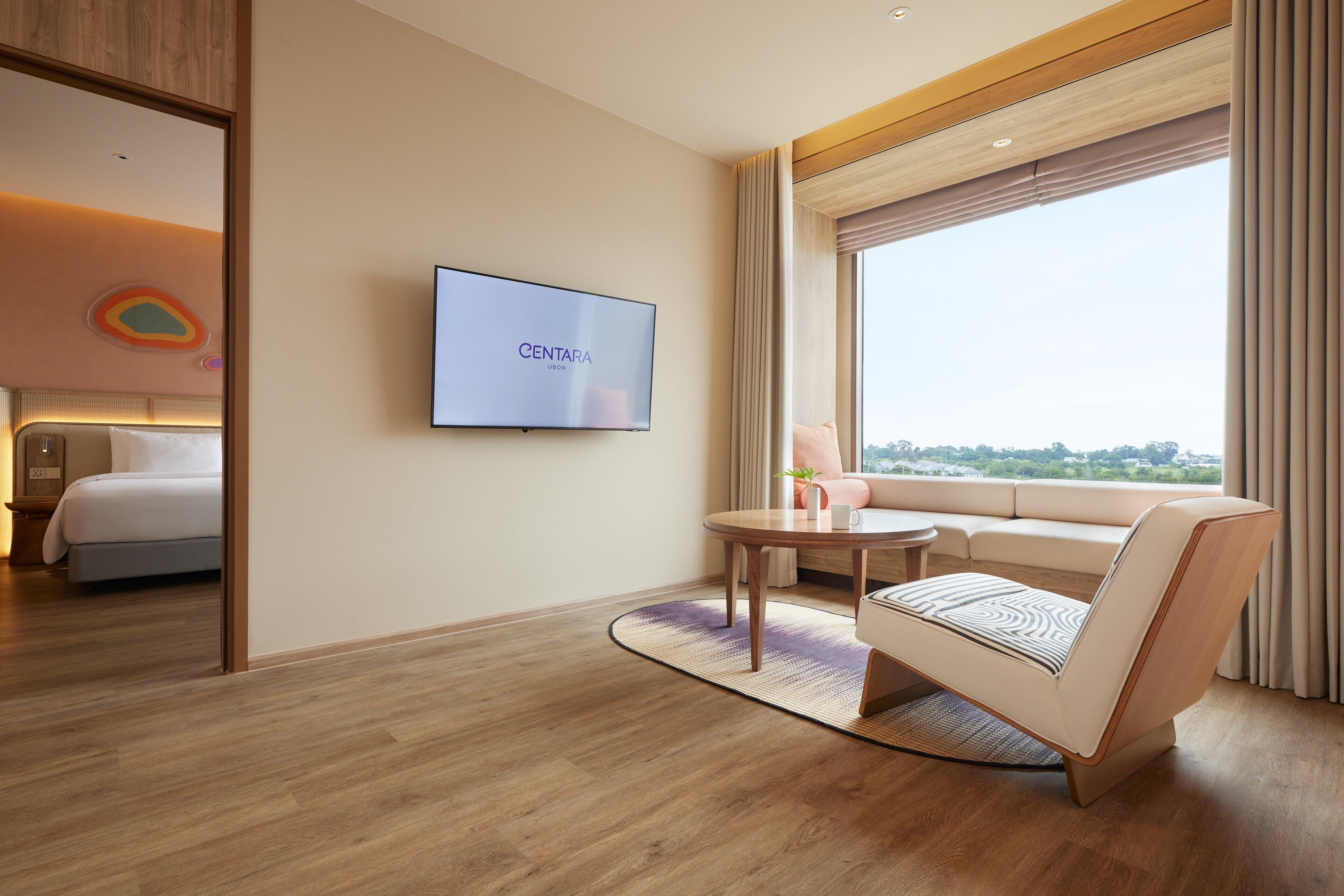 Una habitación de hotel moderna con cama, televisor, sofá y vista a la ciudad.