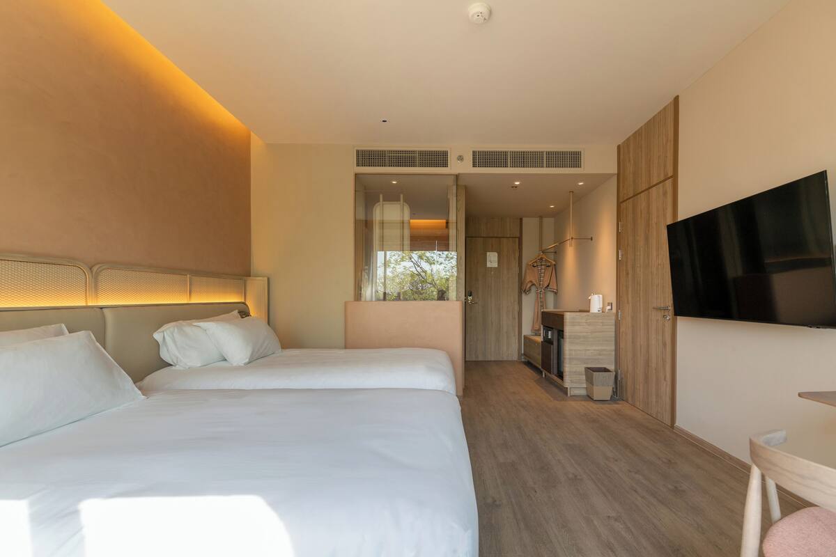 Una habitación de hotel con una cama grande, televisión y piso de madera.