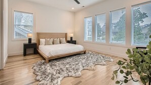 A bedroom with a large bed, a ceiling fan, and multiple windows with blinds. - 4 - Music Row Modern - The Music City Collection (Nashville)