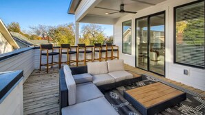 A modern outdoor patio with a sofa, chairs, and a coffee table. - 5 - Music Row Modern - The Music City Collection (Nashville)