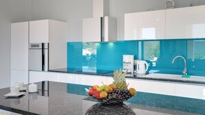 A modern kitchen with white cabinets, a stainless steel range hood, and a fruit bowl on the counter. - Villa Rachele (Istria - Rakalj) (Rakalj)