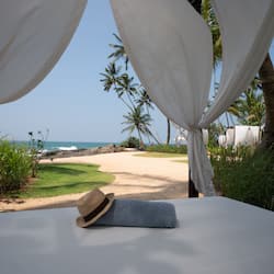 Enjoy the serene beach view from your room, featuring a comfortable bed and a path to the sandy beach.