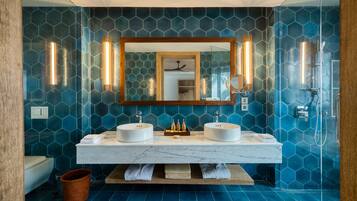 Een badkamer met twee wastafels, een grote spiegel en een douche.