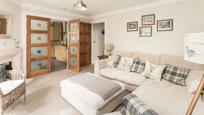 A cozy living room with a sofa, a small table, and a fireplace. - An Sulaire (North Berwick)