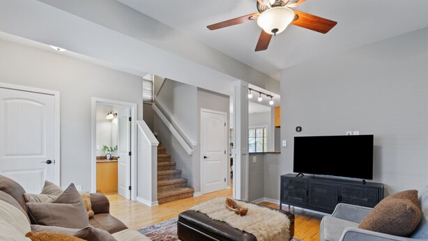A spacious living room with a staircase, a flat-screen TV, and a cozy seating area. - Red Barn Roost • Cozy Stay Near Downtown (Loveland)