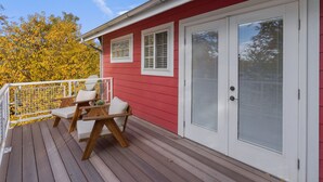 A red building with a deck, white shutters, and a door with a window. - Red Barn Roost • Cozy Stay Near Downtown (Loveland)