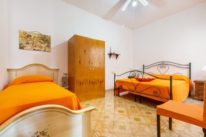 A bedroom with two beds, a wooden wardrobe, and a tiled floor. - 2658 Appartamento Cecilia by Barbarhouse (Porto Cesareo)