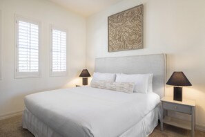 Una camera da letto con un letto grande, due comodini con lampade e un'opera d'arte appesa al muro.