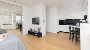 Un apartamento moderno con cocina, comedor y un espejo grande.