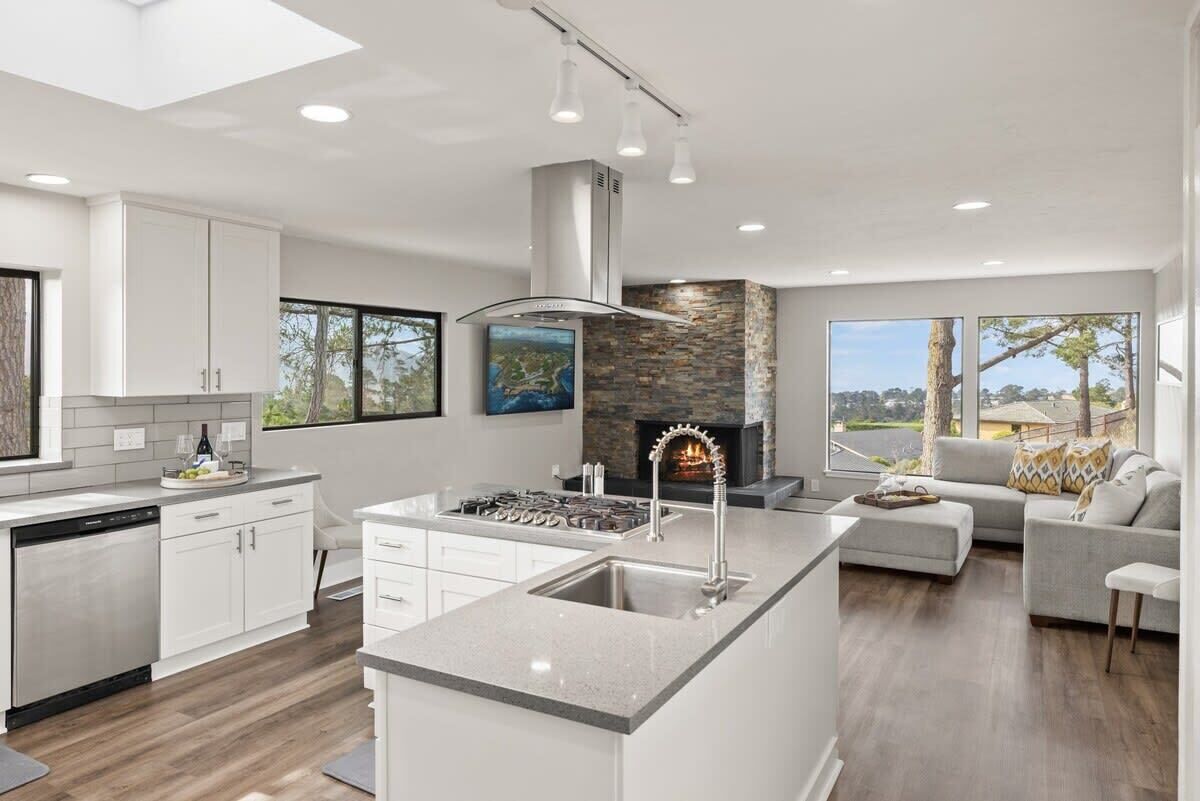 Una cocina moderna con una isla central, una chimenea y vistas al exterior.