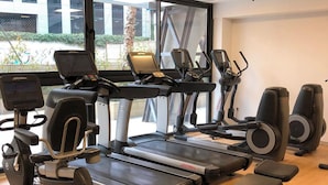 A gym with treadmills, elliptical machines, and weight benches. - E-kilibrio Hotel & Apart-Suites (Madrid)