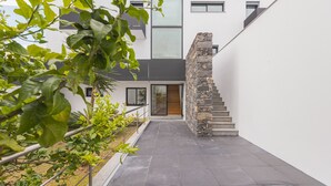 Un bâtiment moderne doté d’un escalier en pierre, d’une entrée avec une porte en verre et d’un chemin pavé.