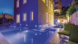 Un bâtiment moderne doté d’une piscine et d’un espace extérieur aménagé pour se détendre.