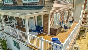 A multi-level deck with outdoor furniture, railings, and a small garden area.