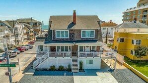 A two-story house with a front porch, a visible garage, and a street view.