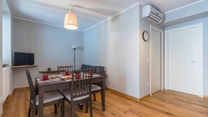 Un comedor con mesa de madera, sillas y una lámpara colgante.