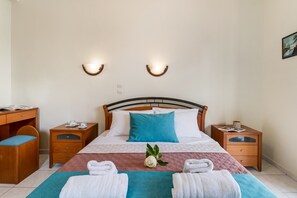 A neatly arranged hotel room with a bed, two bedside tables, a desk, and a chair.