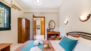 A hotel room with a bed, a desk, a wardrobe, and a bathroom visible through an open door. - Apartment "Nikoleta 1" with Sea View, Terrace & Wi-Fi (Lefkada)