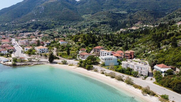 A coastal town with buildings along the beachfront, a road leading to the sea, and mountains in the background. - Apartment "Nikoleta 1" with Sea View, Terrace & Wi-Fi (Lefkada)