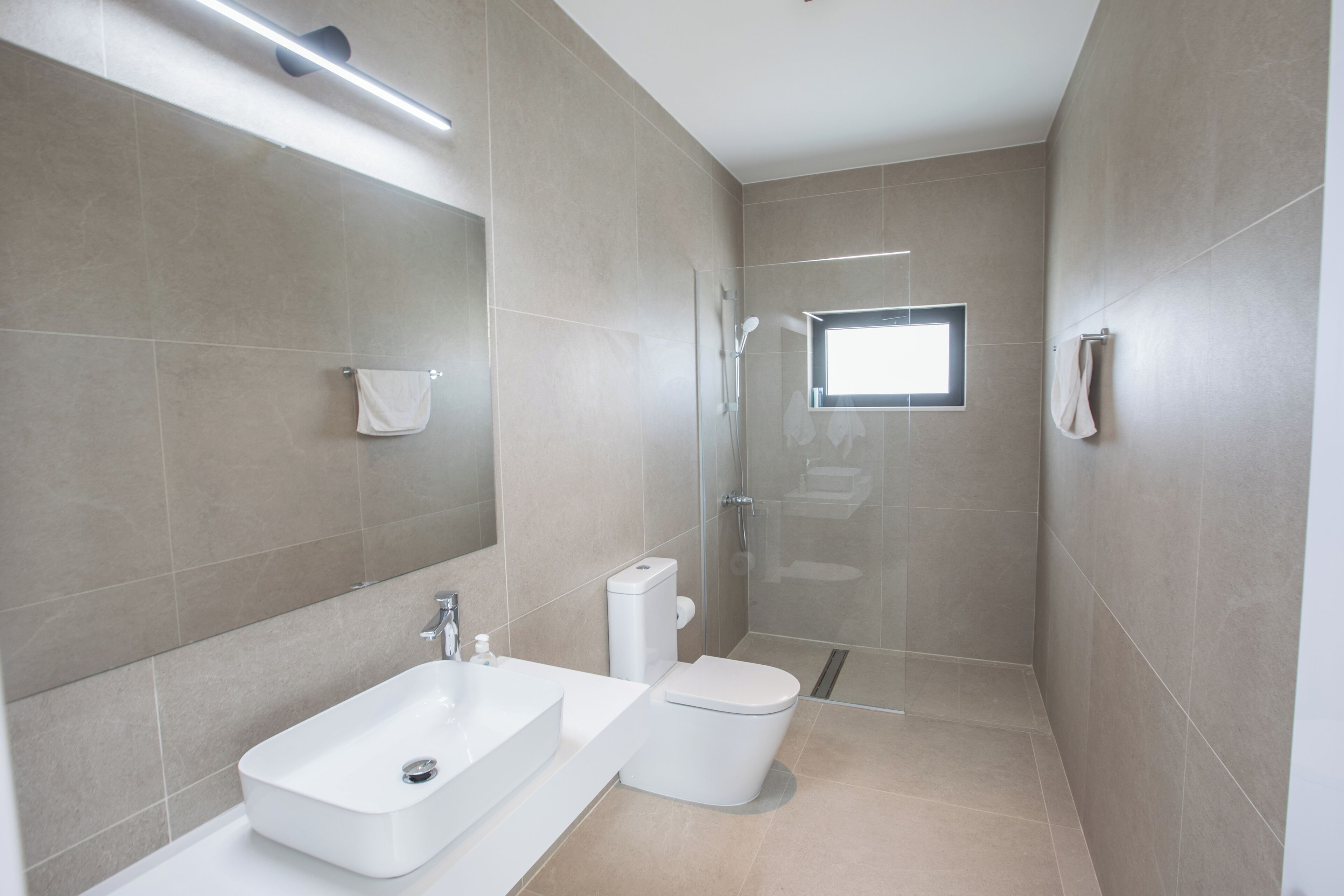Un baño moderno con lavabo, inodoro y ducha.