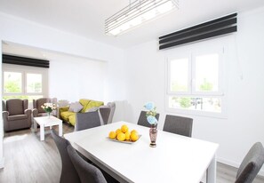 A modern living room with a dining table, sofas, and a coffee table.