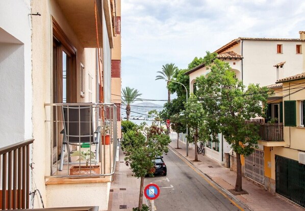 A narrow street with buildings on both sides, a stop sign, and a no parking sign.