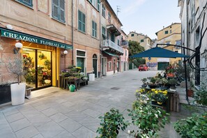 A street with a flower shop named 'CREAZIONI FLOREALI dal 1992' and a red car parked on the street. - Apartment "Casa Federico" near the sea with balcony and Wi-Fi (Levanto)