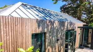 A modern building with a sloped metal roof, wooden exterior walls, and large windows. - Zandvoort Lodge 1 - Amazing couples getaway! (Zandvoort)