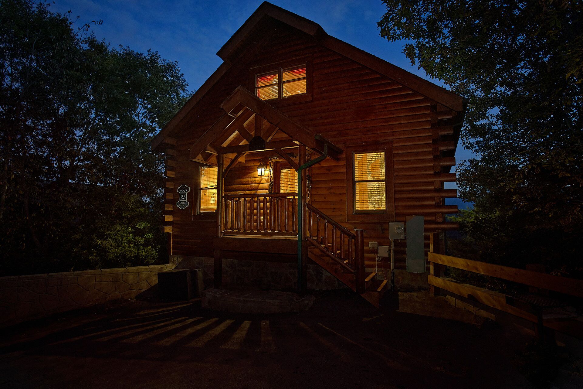 A wooden cabin with a porch and a staircase leading to the entrance.
