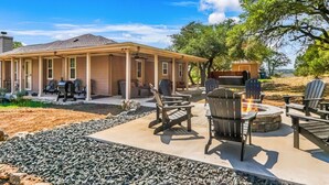 A covered patio with outdoor seating and a fire pit.