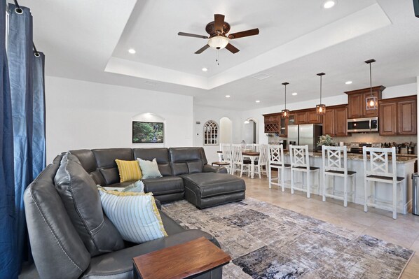 A spacious living area with a sectional sofa, a wooden coffee table, and a large rug.