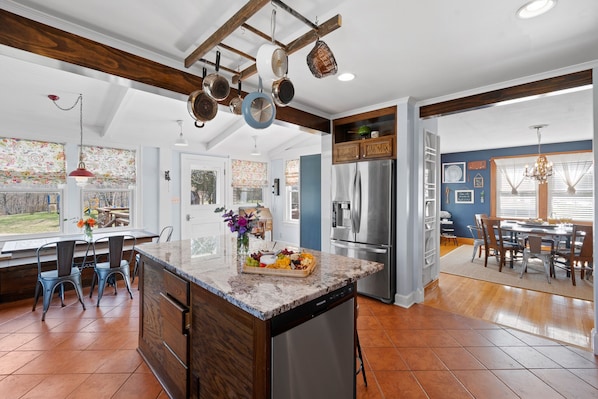 A spacious kitchen with a central island, stainless steel appliances, and a dining area with a large table and chairs. - BACKYARD WANDERLAND - Near ARK & Creation Museum - perfect for big families! (Burlington)