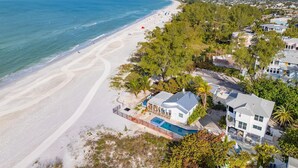 Un quartier résidentiel situé sur la côte, avec une plage, des maisons et une piscine.