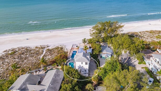 A beachfront property with multiple houses, a swimming pool, and a beach in the background. - Turtle Beach: 2 Homes, Sleeps 10, Gulf Front with 2 Pools! (Holmes Beach)