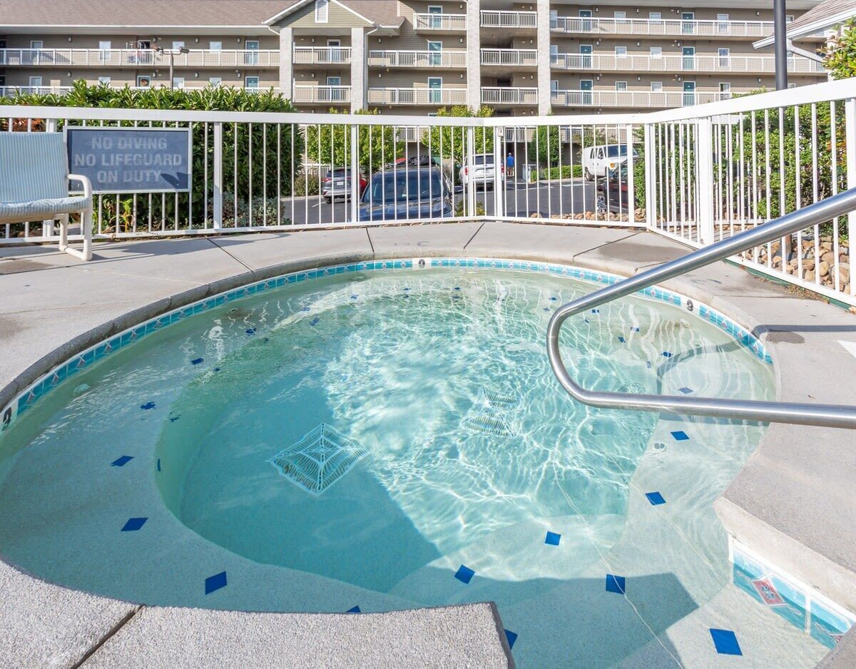 A swimming pool with a no diving sign, a lifeguard duty sign, and a metal railing.