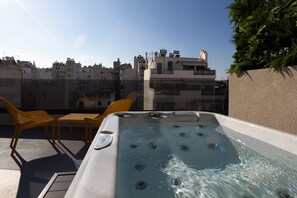Un jacuzzi sur le toit offrant une vue dégagée sur les bâtiments environnants.