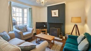 A living room with a sofa set, a coffee table, a television, a fireplace, and a lamp. - Host & Stay | Hall Garth (Pickering)