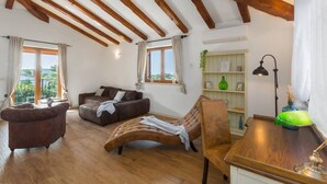 A spacious living room with wooden beams, a sofa, a recliner, a wooden coffee table, and a bookshelf. - Villa Marina with pool, BBQ & parking near Poreč (Jasenovica)