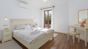A bedroom with a bed, bedside tables, a desk, and a mirror. - Villa Marina with pool, BBQ & parking near Poreč (Jasenovica)