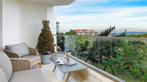 Een balkon met een bank, een tafel en een bloempot.