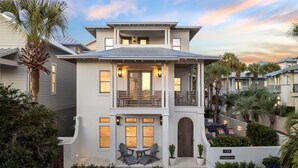 A two-story house with a balcony, a garage, and a driveway.