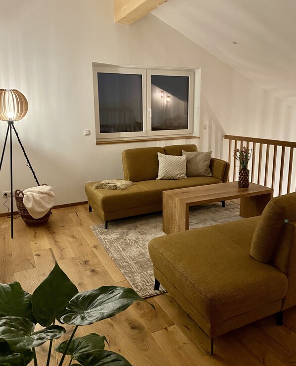 A cozy living room with a sofa, a coffee table, and a floor lamp. - Das Franz 1 (Weitnau)